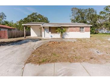 Exterior view of a single-story home with a carport and a partially bricked facade at 1825 134Th St, Largo, FL 33778