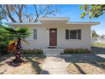 Charming single-story home with a well-maintained lawn, a tidy flower bed, and a quaint front porch at 8608 N 20Th St, Tampa, FL 33604