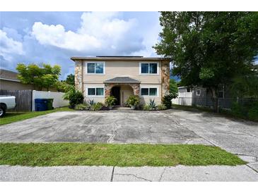 Two-story home featuring beige siding, stone accents, and a well-maintained front yard at 1604 E Waters Ave, Tampa, FL 33604