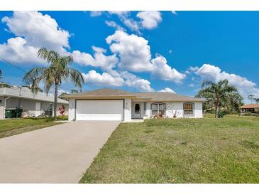 Charming single-story home featuring a two-car garage and well-maintained lawn at 7280 Meroni Blvd, North Port, FL 34291