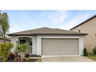 Charming one-story home featuring a two-car garage, landscaped yard, and well-maintained lawn at 15729 Fort Island Pl, Sun City Center, FL 33573