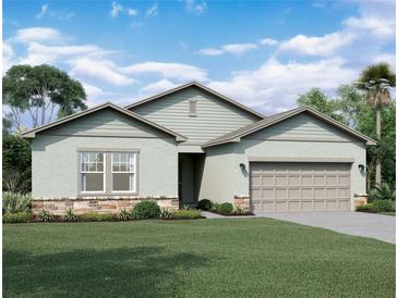 Charming single-Gathering home with stone accents, a well-manicured lawn, and an attached two-car garage at 36183 Canelli Way, Dade City, FL 33523