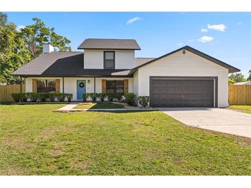 Charming two-story home featuring a well-manicured lawn, a two car garage, and a welcoming blue front door at 5303 Glen Harwell Rd, Plant City, FL 33566