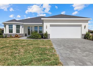 Charming single-story home with a well-manicured lawn and a paved driveway leading to a two-car garage at 7338 N Ficus Tree, Punta Gorda, FL 33955