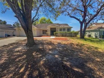 Charming single-story home featuring a well-maintained front yard and a classic exterior design at 8080 Spanish Oak Dr, Spring Hill, FL 34606