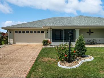 Charming single-story home showcasing a manicured lawn, landscaping, and a two-car garage at 2106 Meadowlark Ln, Sun City Center, FL 33573