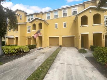 Sunny yellow townhouse with attached garages and well-maintained landscaping adds curb appeal at 8869 White Sage Loop, Lakewood Ranch, FL 34202