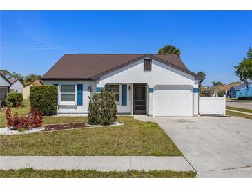 Charming single-story home featuring a well-manicured lawn and an attached one car garage at 1225 E Corktree Cir, Port Charlotte, FL 33952