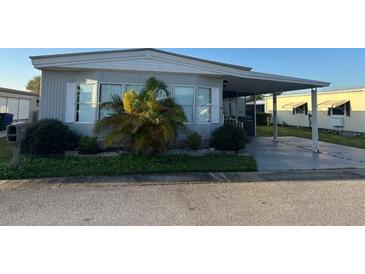 Well maintained single Gathering home features tidy landscaping, carport and mature tropical foliage at 125 Dolphin S Dr, Oldsmar, FL 34677