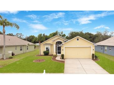 Charming single-story home with a well-manicured lawn and attached two-car garage at 13202 Golf Ridge Pl, Hudson, FL 34669
