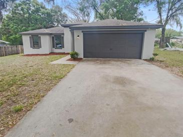 Charming single-story home with a well-maintained lawn, gray garage door, and inviting curb appeal at 27118 Fernery Ave, Brooksville, FL 34602