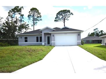 Charming single-story home featuring a well-manicured lawn and a two-car garage at 3092 Crowder St, Port Charlotte, FL 33980
