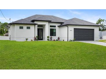 A modern home with white stucco, a gray roof, a dark garage door, and a green lawn at 2805 Anniston Rd, North Port, FL 34288