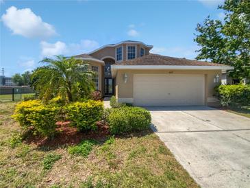 Charming home featuring a well-manicured lawn, lush landscaping, and a two-car garage at 4249 Hawksley Pl, Wesley Chapel, FL 33545