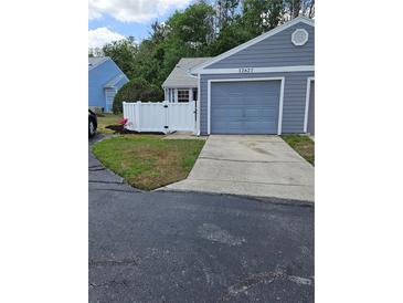 Charming home featuring a one-car garage, a well-maintained lawn, and a privacy fence at 12627 W Cherrydale Ln, Hudson, FL 34669