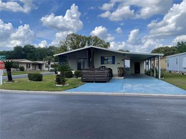 Charming single-story home featuring a covered carport and a screened-in porch, set amidst lush landscaping at 34315 Timberland Blvd, Wesley Chapel, FL 33543