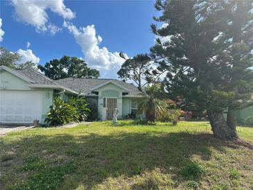 Charming single-story home featuring a well-maintained lawn and beautiful landscaping at 21285 Peachland Blvd, Port Charlotte, FL 33954