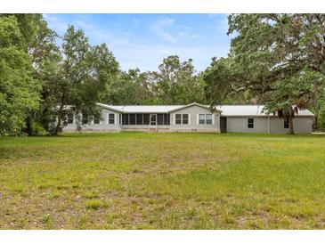Single story home with metal roof and large front yard at 10809 Cedar Cove Drive, Thonotosassa, FL 33592