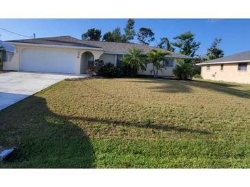 Charming single-story home with well-maintained landscaping and a two-car garage, showcasing curb appeal at 89 Mark Twain Ln, Rotonda West, FL 33947