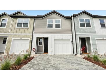 Charming townhouse featuring a paver driveway and attached one-car garage at 7272 Deer Valley Circle, Tampa, FL 33635
