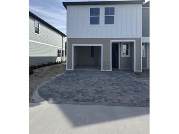 Modern two-story townhome featuring an attached garage and a neatly paved driveway at 7284 Deer Valley Cir, Tampa, FL 33635