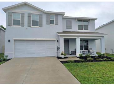 Charming two-story home with a well-manicured lawn, covered porch, and light blue exterior at 3715 Capri Coast, Plant City, FL 33565