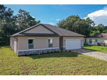 New construction single-Gathering home with a two-car garage, stone accents and a well-manicured lawn at 80 Sequoyah Dr, Port Charlotte, FL 33954