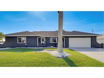 Beautiful single-story home with a well-manicured lawn and a two-car garage at 5202 Forbes Ter, Port Charlotte, FL 33981