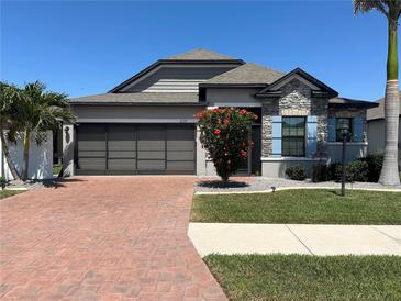 Charming single-story home featuring a two-car garage, brick driveway, and well-maintained landscaping at 2137 Apian Way, Port Charlotte, FL 33953