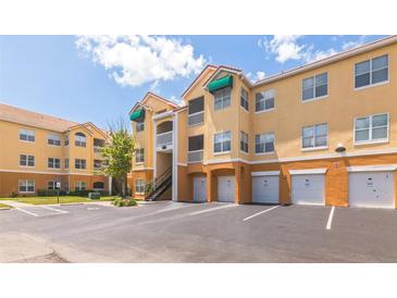 Inviting condo building featuring private garages, stairs to upper units, and lush landscaping under a sunny sky at 10764 70Th Ave # 3305, Seminole, FL 33772