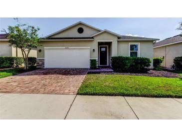 Charming single-story home with a brick driveway, attached garage, and well-manicured landscaping at 25242 Carnation Sedge Way, Land O Lakes, FL 34639