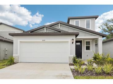 Charming two-story home featuring an attached garage and professionally landscaped front yard at 2320 E Newsome Rd, Plant City, FL 33565
