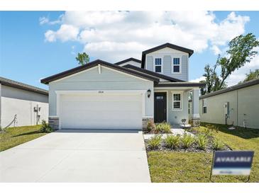 Charming home featuring a two-car garage, manicured lawn, and a welcoming front entrance at 3904 Radiant Mountain Dr, Plant City, FL 33565