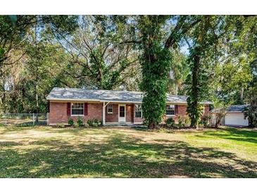 Charming one-story brick home with a well-maintained front yard and mature trees at 2902 Little Rd, Valrico, FL 33596