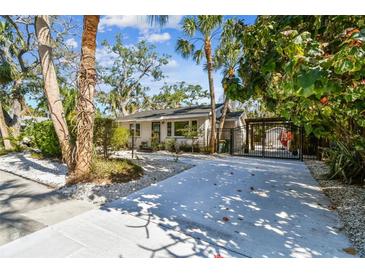 Wide driveway with white gravel and lush greenery, leading to a charming home at 913 Tennessee Ln, Sarasota, FL 34234