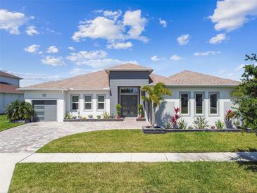 Beautiful single-story home featuring a well manicured lawn, brick paved driveway, and a welcoming front entrance at 8936 Sanders Tree Loop, Wesley Chapel, FL 33545