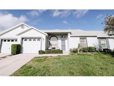 Charming home featuring a well-manicured lawn and inviting entry with cozy outdoor seating at 4217 Avanti Cir, New Port Richey, FL 34655