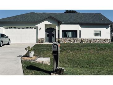 Charming single Gathering home with a neutral color scheme, stone accents, and well manicured yard at 4666 Clarke St, North Port, FL 34286