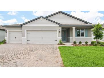 Charming single-story home with a two-car garage, and inviting front yard with beautiful brick paver driveway at 1787 Draughton Dr, Zephyrhills, FL 33541