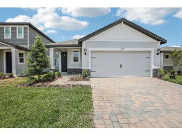 Charming single-Gathering home with a two-car garage and a beautifully landscaped front yard at 1839 Brekey Way, Zephyrhills, FL 33541