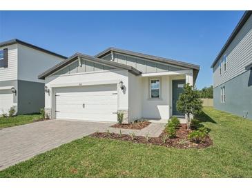 Charming single-story home with a well-manicured lawn, a two-car garage, and inviting curb appeal on a sunny day at 1861 Brekey Way, Zephyrhills, FL 33541