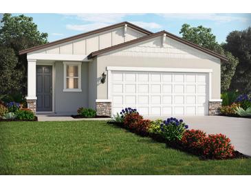 Charming single-story home with a manicured lawn and colorful flower beds, offering great curb appeal at 441 Lazy Shore Dr, Nokomis, FL 34275