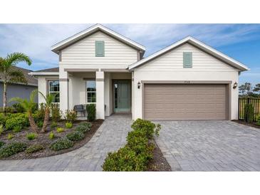 Charming two-story home with a two-car garage, beautifully landscaped front yard, and a welcoming walkway at 9548 Vibrant Lane, Venice, FL 34292