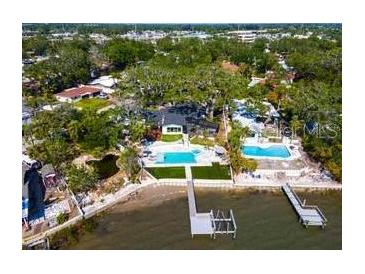 Stunning aerial view of waterfront property, featuring two pools, a dock, and lush greenery in a desirable neighborhood at 8390 40Th N Ave, St Petersburg, FL 33709