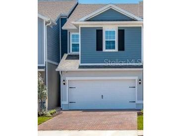 Charming two-story home featuring a two-car garage, blue siding, and classic black shutters at 42854 Park View Dr Way, Punta Gorda, FL 33982