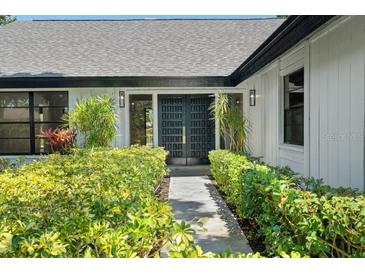 Inviting front entrance with lush landscaping and stylish, modern double doors at 5474 Dominica Cir, Sarasota, FL 34233