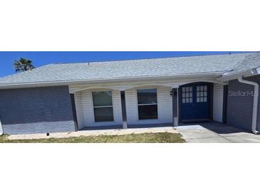 Charming single-story home featuring a blue front door and neutral brick and siding at 3309 Rock Valley Dr, Holiday, FL 34691