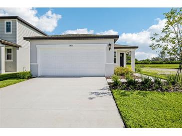 New home featuring a two car garage, and newly installed landscaping at 14118 Crutchfield Ct, Parrish, FL 34219