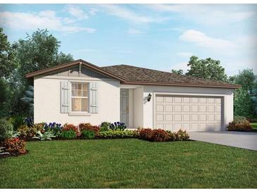 Charming single-story home with a two-car garage, well-manicured lawn, and colorful landscaping at 7735 Gilchrist Springs Dr, Parrish, FL 34219