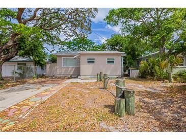 Charming single-story home featuring mature trees and unique front yard details at 912 Magnolia Dr, Clearwater, FL 33756